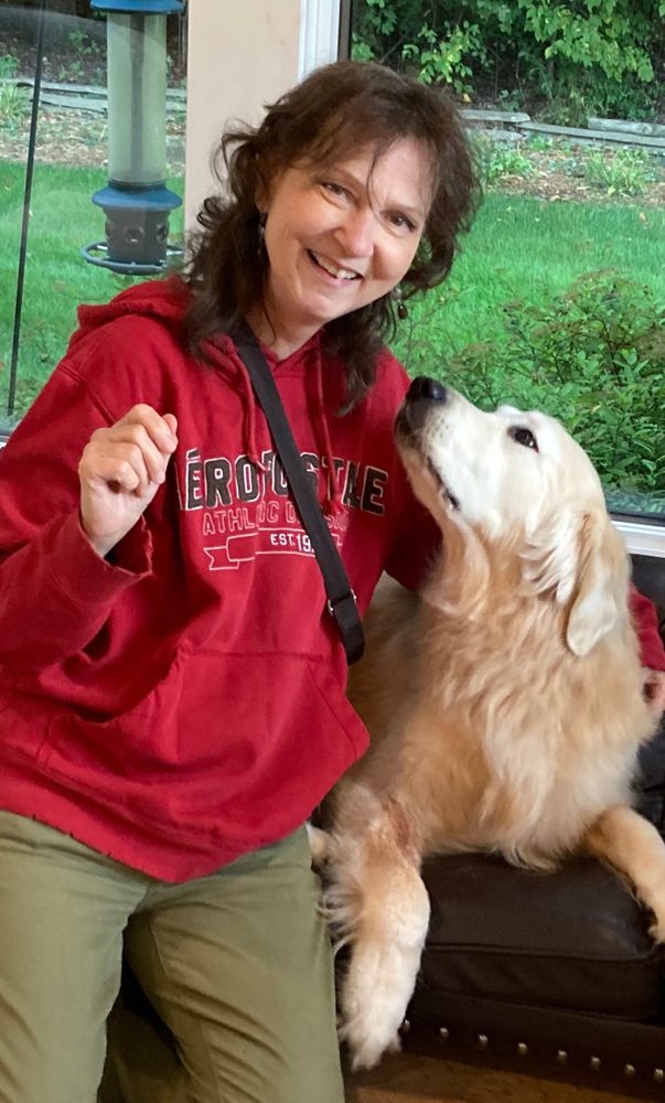 Anna Rita Walsh smiling with a happy golden retriever